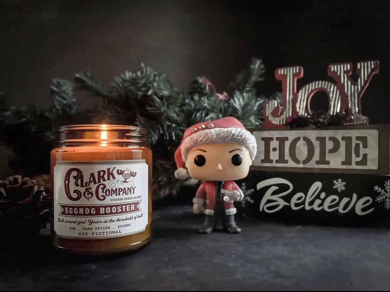 Holiday soy candle with garland, funky pop, and holiday sign.