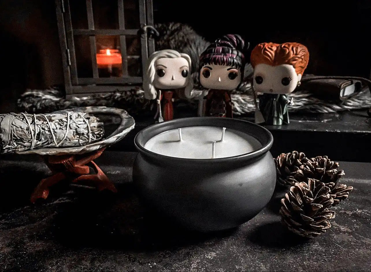 Black cauldron-shaped candle with three wicks.