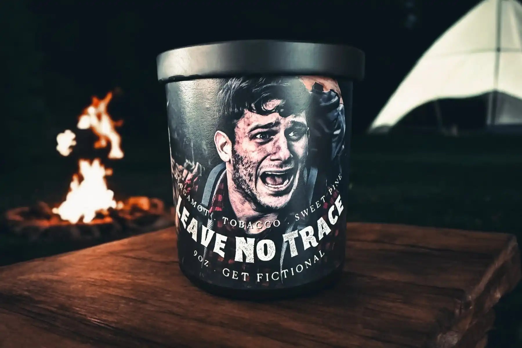 A cylindrical container with a black lid, featuring a graphic of a man screaming and the words ’LEAVE NO TRACE’.