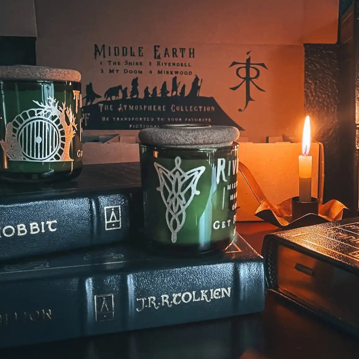 A set of two green Lord of the Rings themed candles with white designs on them.